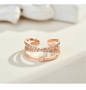 Macro view of adjustable rose gold layered cross ring with sparkling pavé crystals