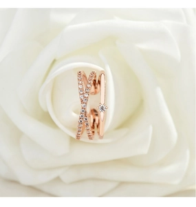 Close-up of rose gold double-layered criss-cross ring with pavé zircons in a white rose