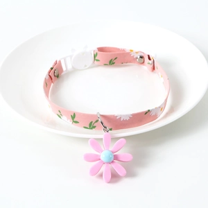 Detail of adjustable pink daisy pet collar with floral pendant and plastic buckle