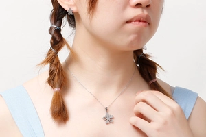 Gros plan d'un ensemble de collier et boucles d'oreilles fleur argenté sur un mannequin
