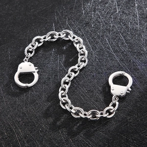 Macro view of stainless steel handcuffs charm with thick silver O-chain necklace