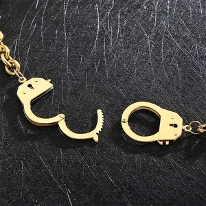 Minimalist golden stainless steel handcuff link chain necklace on black leather background