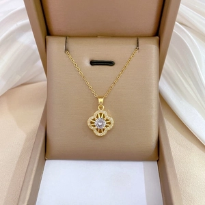Detail of gold four-leaf clover pendant with large center stone in a gift box