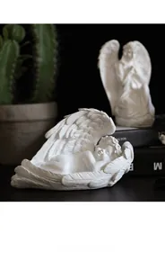 Détail d'un ange endormi en résine blanche avec textures de plumes finement sculptées