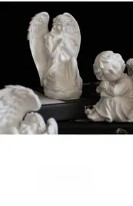 Gros plan d'une élégante statue d'ange priant en résine blanche aux textures classiques