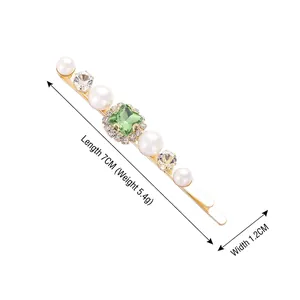Elegant gold hair clip with green square gemstone, pearls and crystals on white background