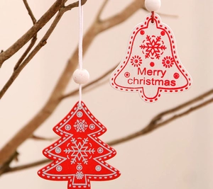 Detail of red and white wooden bell and tree ornaments hanging on branches