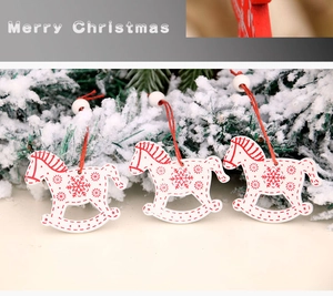 Three red and white wooden rocking horse ornaments set on artificial snow and pine