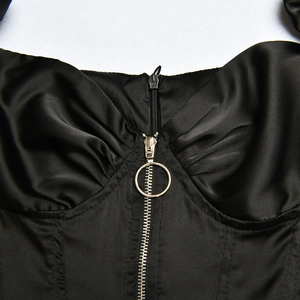 Detailed view of black satin corset top with front ring-pull zipper and pleated bust