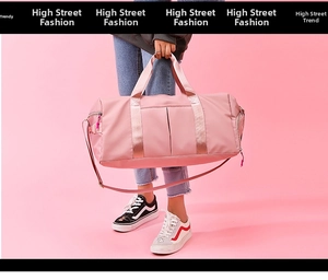 Pink fitness travel bag with adjustable strap and shoe compartment on pink background