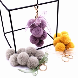 Creative plush grape keychain with lace bow and gold keyring in purple, yellow, and grey colors