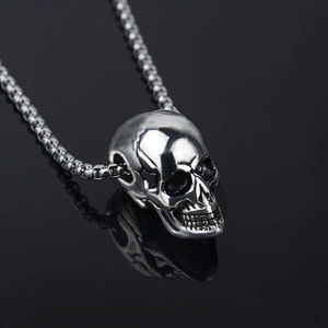 Polished silver skull pendant necklace with box chain for men on black mirror background