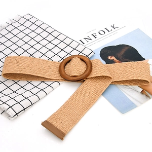 Detail of khaki braided straw belt featuring a round wooden buckle and natural texture