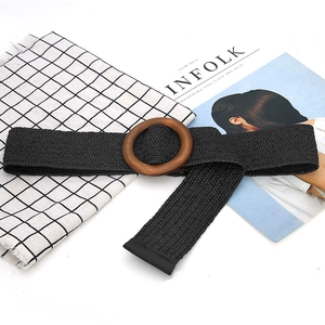 Detail of black woven elastic belt with a round wooden buckle on a checkered background