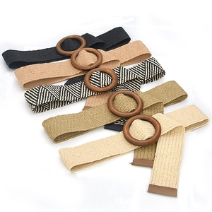 Detail of woven elastic belts with round wooden buckles in assorted neutral colors