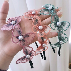 Three fairy-style lace butterfly headbands with pearls in pink, orange, and green colors