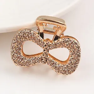 Detailed macro view of the gold-plated alloy butterfly hair claw with embossed rose pattern