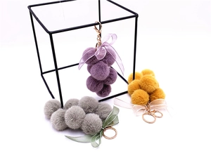 Plush grape keychains in purple yellow and grey with lace bows and golden metal hooks