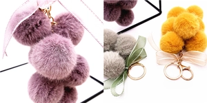 Macro detail of plush grape cluster keychain with ribbon bow and gold lobster clasp