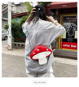 Outdoor shot showing a mushroom-shaped crossbody bag with red and white PU leather details