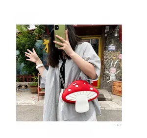 Street style shot of a cute red and white mushroom crossbody bag with silver chain