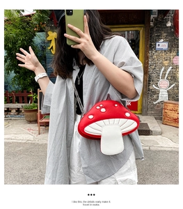 Detail of red and white mushroom shaped crossbody bag with metal chain strap