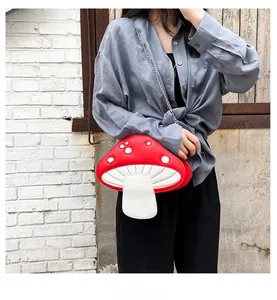 Detail view of a creative red mushroom shaped PU leather crossbody bag with silver chain
