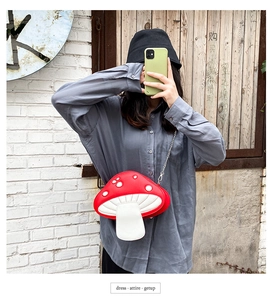 Detail of red and white mushroom shaped PU leather crossbody bag with silver chain strap