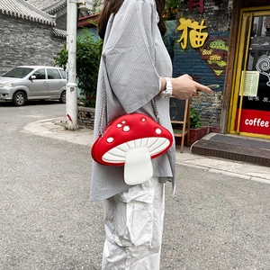 Outdoor street style shot of a red and white mushroom-shaped PU leather crossbody bag