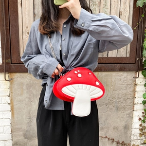 Detail view of red and white mushroom crossbody bag with realistic gills and chain strap