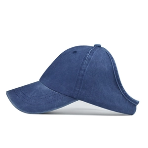 Close-up of dark blue washed cotton ponytail baseball cap featuring a large rear opening