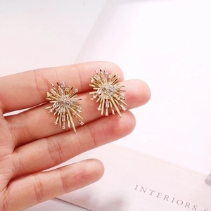 Macro shot of gold starburst earrings featuring radiant cubic zirconia stones