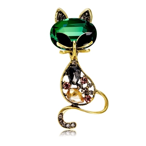 Close-up of a vintage cat brooch with green emerald eyes and multi-colored crystal stones