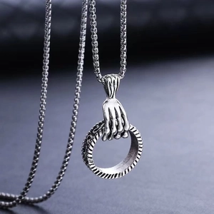 Gothic hip hop necklace featuring a skeleton hand holding a textured ring pendant