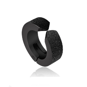 Detail of matte black clip-on earring with textured finish and punk style C-shape design