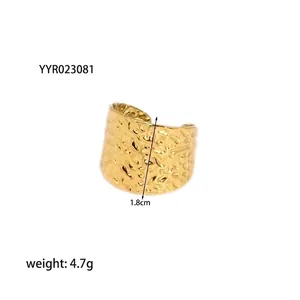 Dettaglio che mostra la larghezza di 1,8 cm e la texture martellata dell'anello aperto 18K