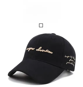 Close-up of gold cursive embroidery on a premium black cotton baseball cap