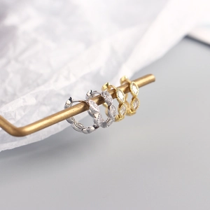 Macro shot of silver and gold marquise-cut zircon hoop earrings with beaded details