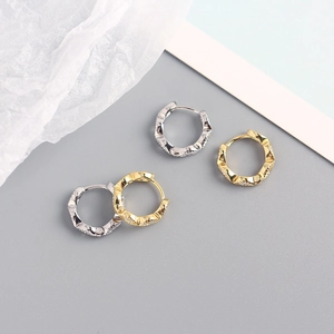 Detailed view of gold and silver bamboo-shaped S925 sterling silver hoop earrings with stones