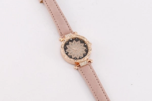 Detail of rose gold watch case with crystal-encrusted lotus dial and pink suede strap