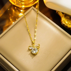 Elegant gold bow pendant necklace with sparkling round crystal in a luxury jewelry box
