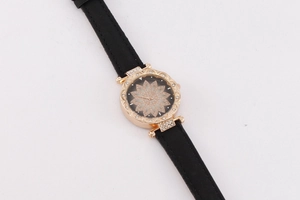 Detail of rose gold watch with floral crystal dial and elegant black leather strap