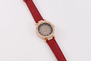 Detail of rose gold starry watch with diamond flower dial and red leather strap