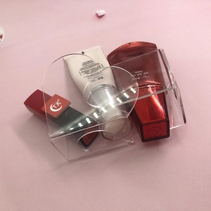 Close-up of transparent acrylic U-shaped makeup organizer tray on a pink background