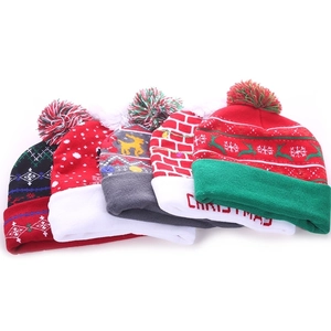 Group of festive LED Christmas knit beanies with colorful patterns and pompoms