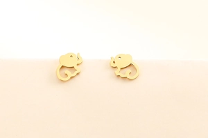 Close-up of golden elephant stud earrings in titanium steel on beige background