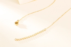 Detailed macro view of the golden O-chain with a lobster clasp and extension link