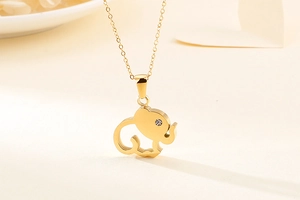 Detail of a hollow elephant necklace in gold finish with small crystal eye detail