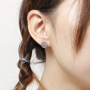 Élégantes boucles d'oreilles trèfle évidé en acier argenté portées par un mannequin