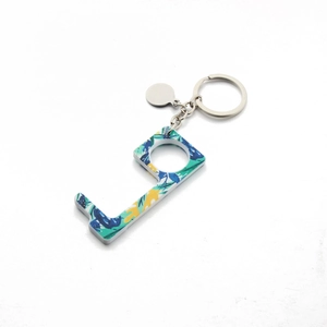 Detailed macro view of an L-shaped acrylic hygiene keychain with tropical floral prints